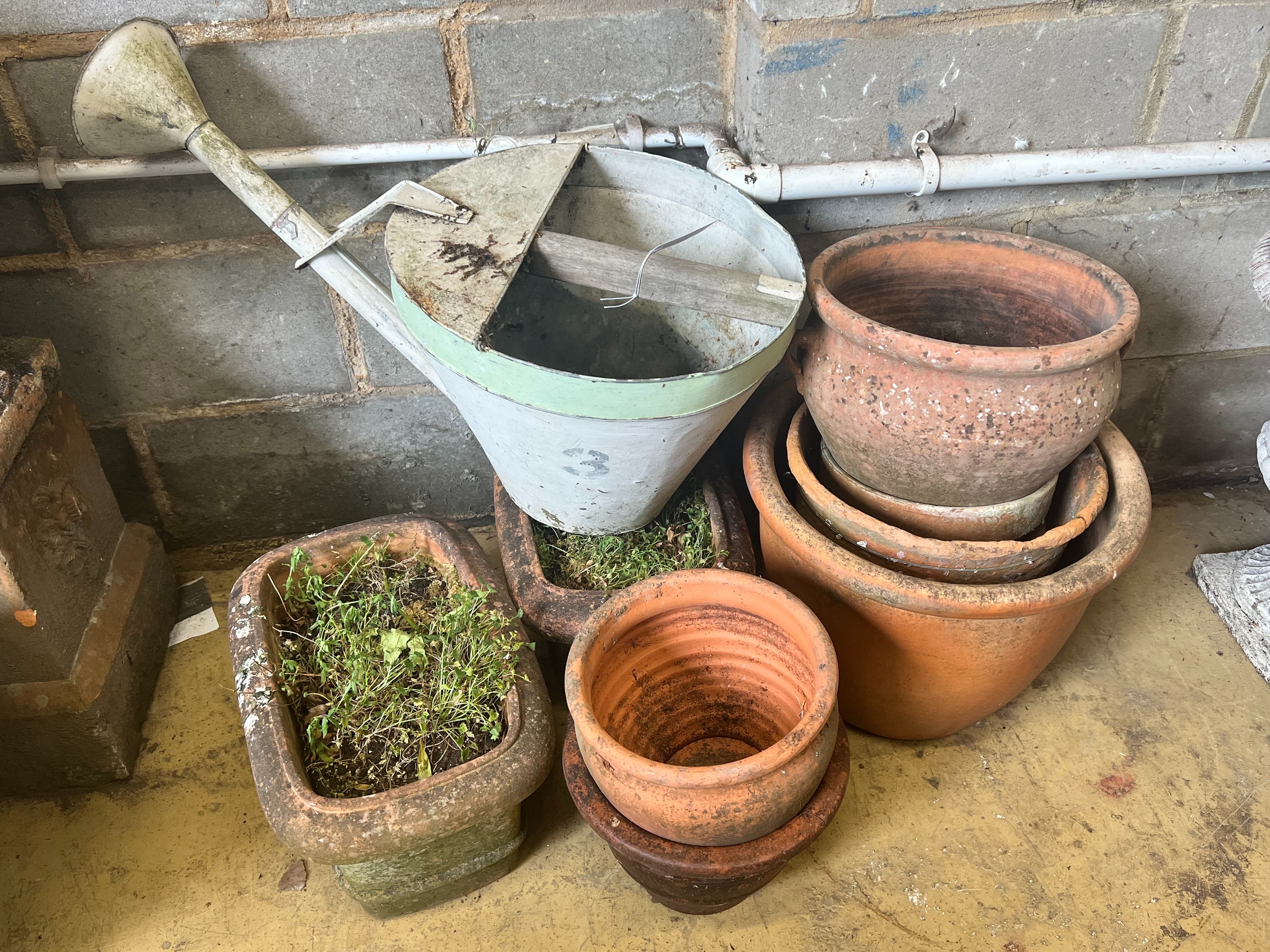 A pair of rectangular terracotta garden planters, width 40cm, a vintage watering can and six circular terracotta planters